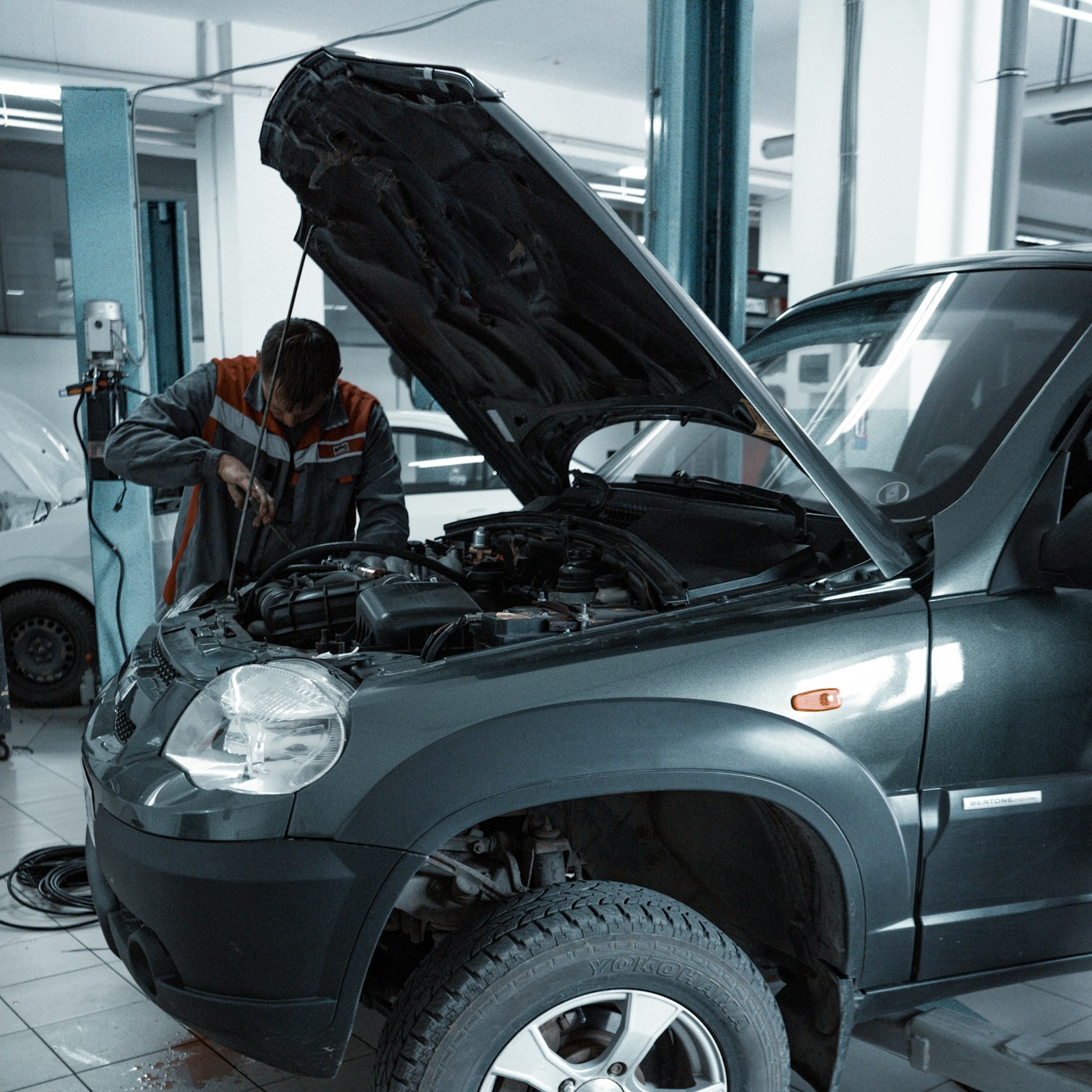 Mobile mechanic working on a car at a customer's home