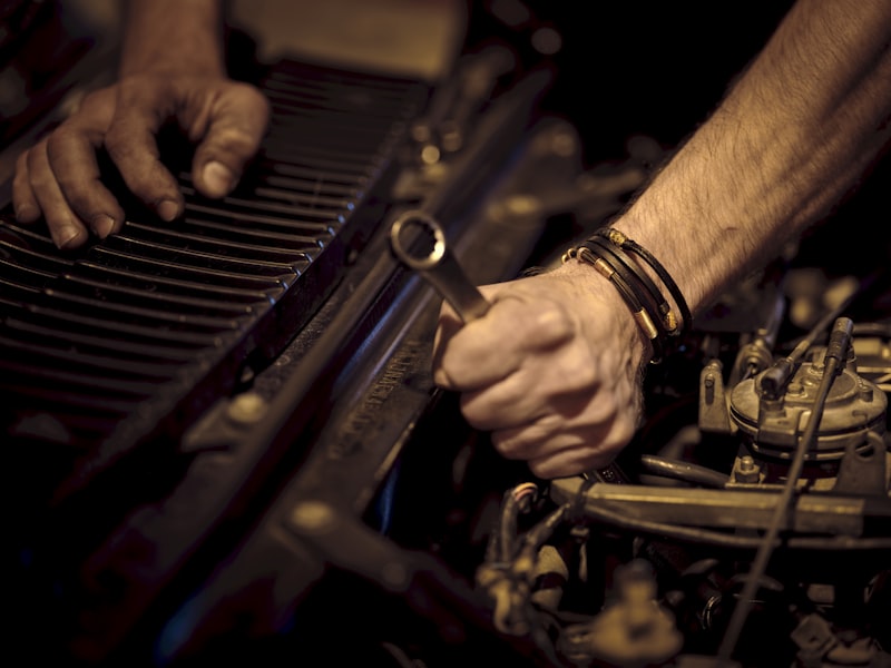 Mechanic's hands repairing an engine with a spanner